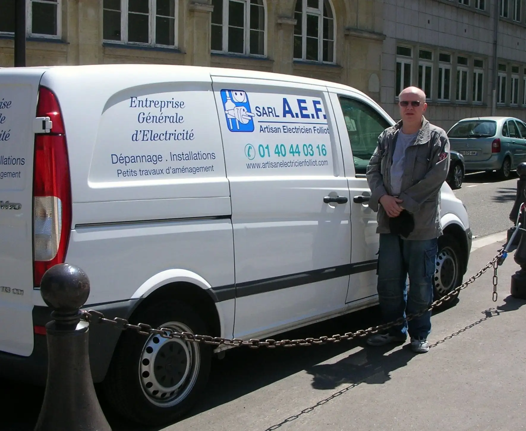 Artisan électricien paris 14 devant sa camionnette d'intervention