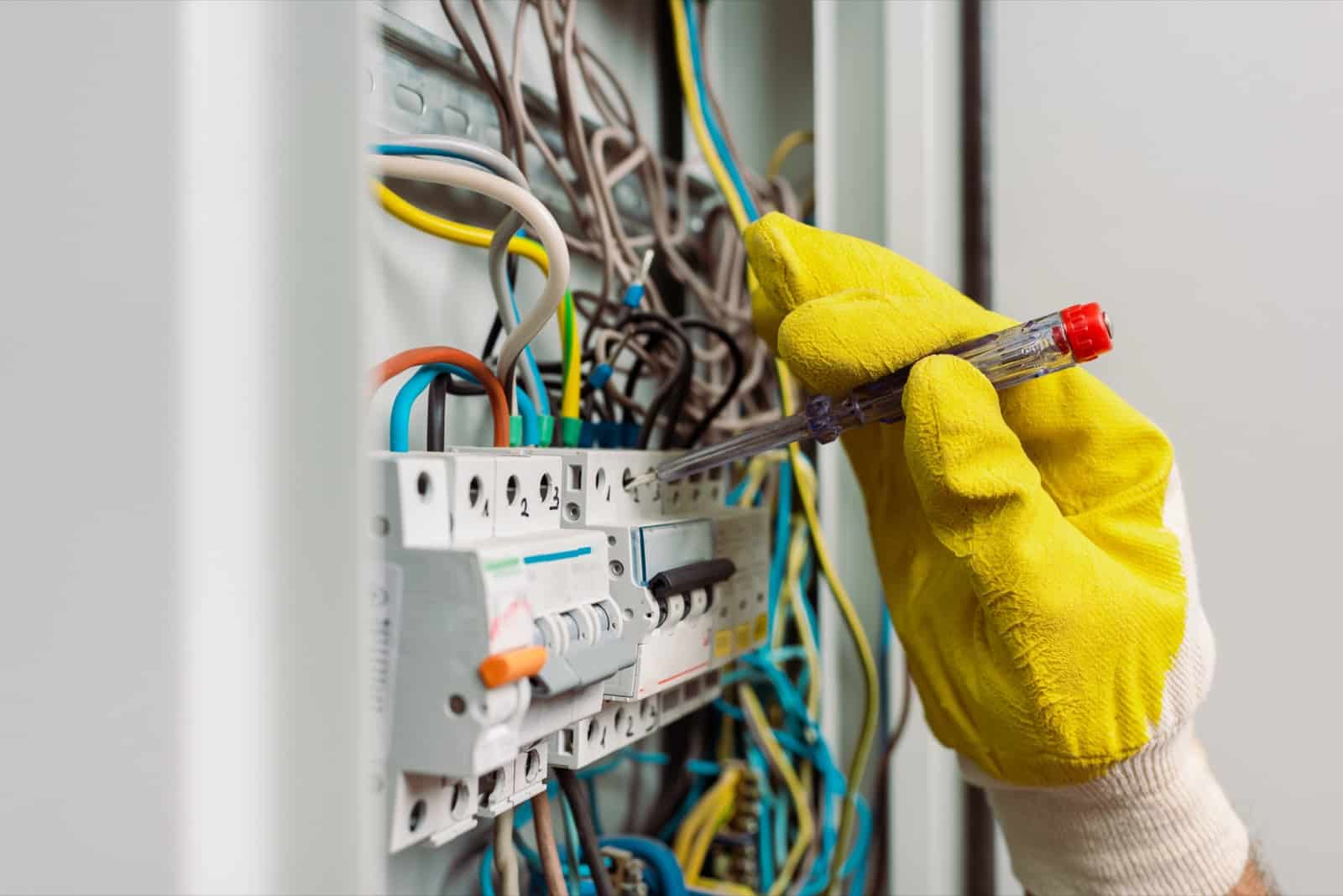 Électricien réalisant la maintenance préventive d'un tableau électrique