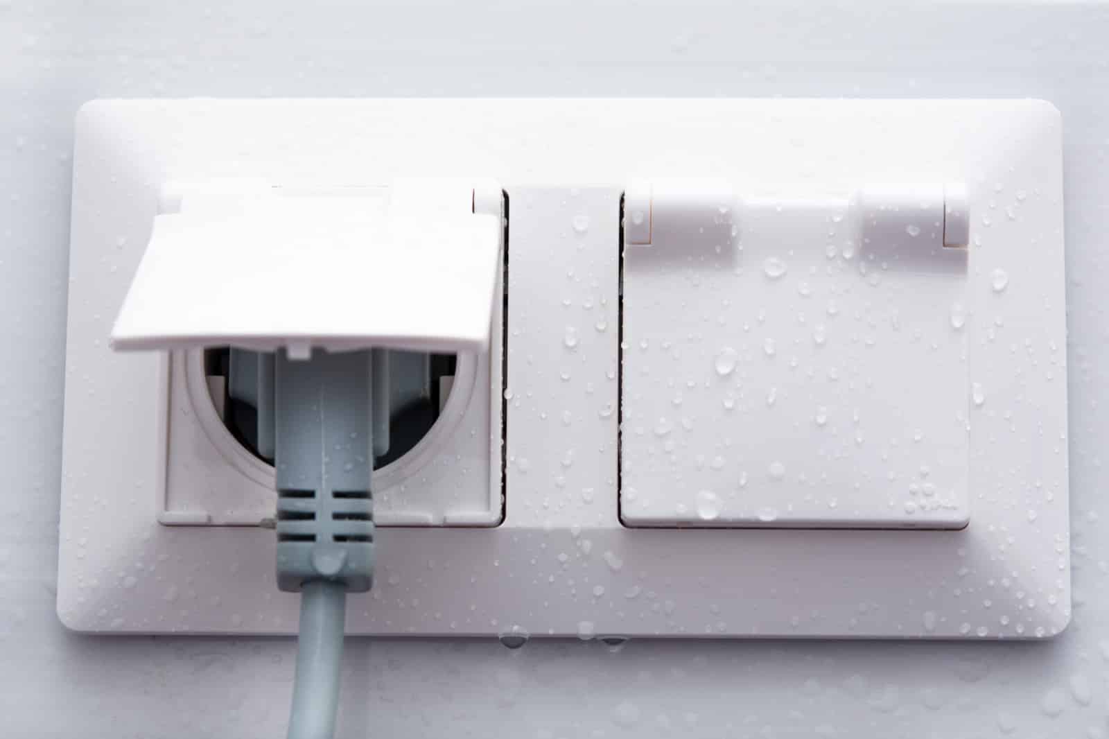 Prise et interrupteur installés hors-volume dans une salle de bain conforme à la norme électrique