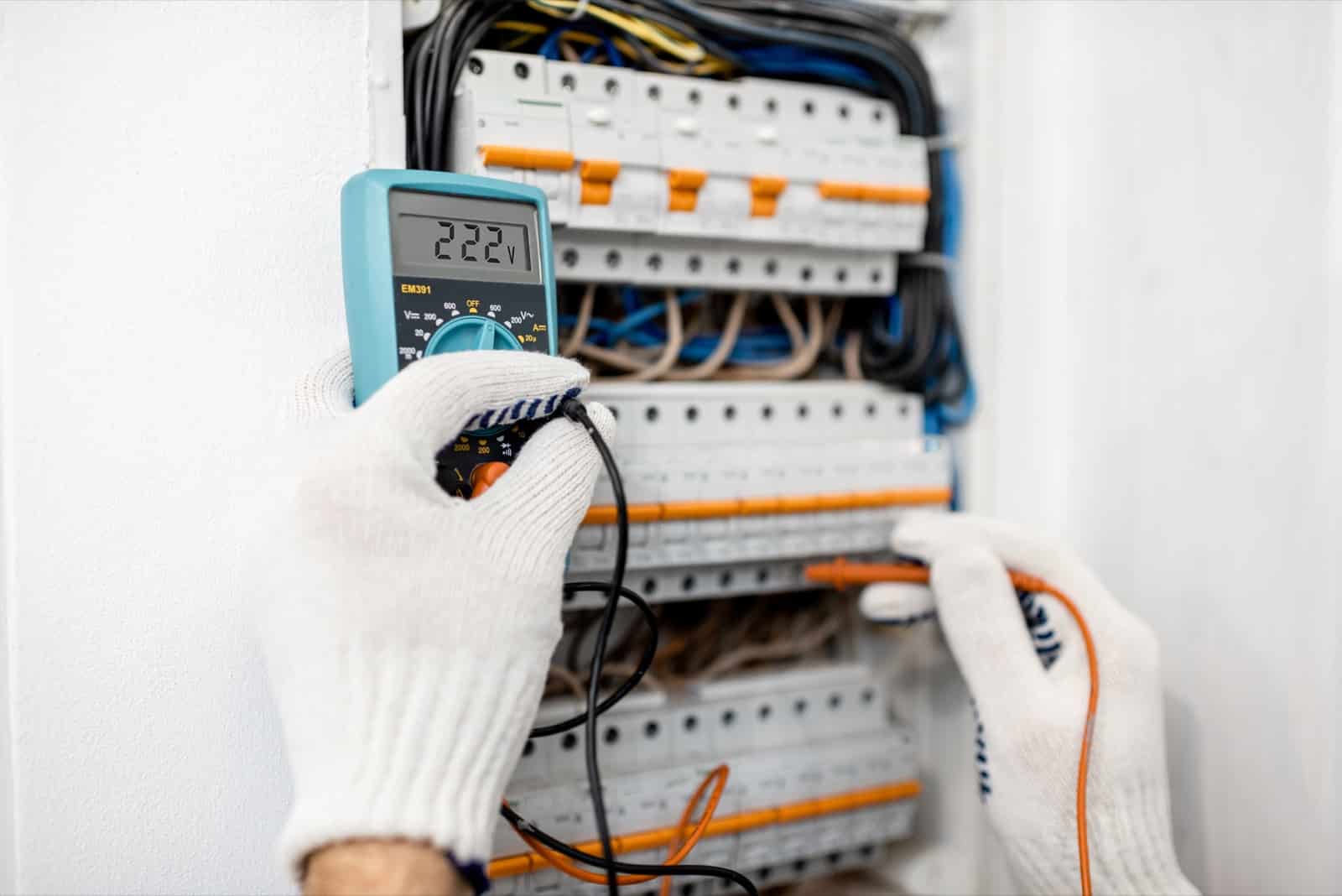 Particulier diagnostiquant une panne électrique devant son tableau électrique